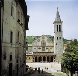 Blick auf eine Kirche mit Rundbögen in einer Stadt auf der Strecke von Florenz nach Rom