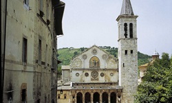 Blick auf eine Kirche mit Rundbögen in einer Stadt auf der Strecke von Florenz nach Rom