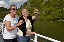 Zwei Frauen stehen an Deck eines Donaukreuzfahrtschiffes und genießen den schönen Ausblick.