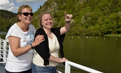 Zwei Frauen stehen an Deck eines Donaukreuzfahrtschiffes und genießen den schönen Ausblick.