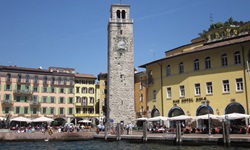 Blick auf einen Hafen am Gardasee mit Promenade und einem Turm mit Uhr