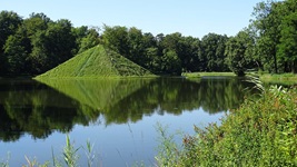 Blick über die Spree zu einer pyramidenformigen Grasinsel