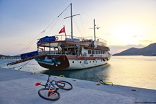 Ein Mountainbike vor der Inselhüpfen-Motoryacht, die im Hafen auf die Rückkehr ihrer Gäste wartet.