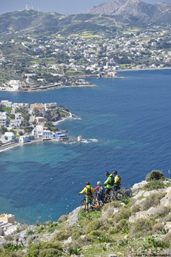 Vier Mountainbiker machen auf der Insel Leros Pause und genießen den Ausblick auf die Adria.