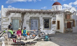 Vier Mountainbiker machen im Zentrum von Chora auf der Insel Patmos Pause.