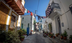 Wäsche trocknet über einer engen Gasse in einem Ort an der Südlichen Griechischen Ägäis.