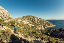 Ein Mountainbiker radelt einen felsigen Trail in der Griechischen Ägäis hinab