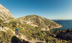 Ein Mountainbiker radelt einen felsigen Trail in der Griechischen Ägäis hinab