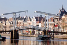 Die Klappbrücke Gravestenenbruck und das Ufer der Spaarne, auf der ein Schiff fährt in Haarlem