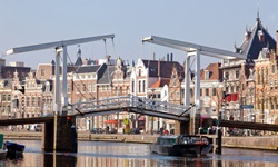 Die Klappbrücke Gravestenenbruck und das Ufer der Spaarne, auf der ein Schiff fährt in Haarlem