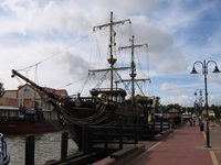 Ein zweimastiger, an ein Piratenschiff erinnernder Holzsegler im Hafen von Leba.