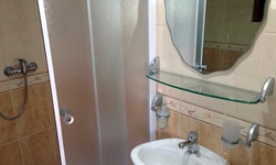 Blick auf eine Dusche und ein Waschbecken eines Badezimmers des Deluxeschiffs Harmonia