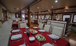 Blick in den eingedeckten Salon mit Essensplatten auf dem Schiff des Deluxeschiffes Harmonia