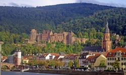 Die Uferpromenade in Heidelberg mit dem Heidelberger Schloss im Hintergrund