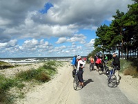 Eine Radlergruppe hat angehalten und schaut noch einmal zurück auf die Ostsee.