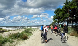 Eine Radlergruppe hat angehalten und schaut noch einmal zurück auf die Ostsee.