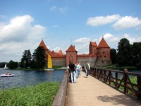 Touristen können auf einer Brücke ganz bequem über den See und zum Eingang der Wasserburg Trakai gelangen.