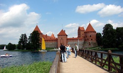 Touristen können auf einer Brücke ganz bequem über den See und zum Eingang der Wasserburg Trakai gelangen.