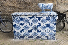 Streetart mit blau weißer Farbe und einer Kuh-Skulptur in Delft