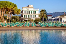 Blick auf den Strand mit Sonnenliegen und das Hotel Gabriella