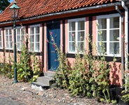 Kleines Haus mit blauer Tür und einer schönen Straßenlaterne auf der Insel Bornholm