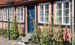 Kleines Haus mit blauer Tür und einer schönen Straßenlaterne auf der Insel Bornholm