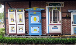 Blick auf restaurierte Türen in weiß, blau, gelb und rot