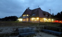 Blick vom Strand der Ostsee zum abendlich beleuchteten Hotel
