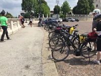 Abgestellte Fahrräder auf einem Parkplatz und Radler, die dort eine Pause machen