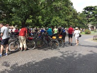 Eine Radlergruppe hat ihre Räder an einem Baum abgestellt, während sie sich nun versammeln
