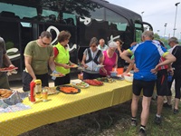 Die Radlergruppe bei der Gruppenreise Venetien bedient sich an einem Buffettisch vor dem schwarzen Reisebus