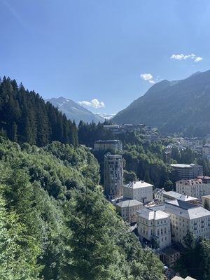 Weitblick über eine in den Bergen eingebettete Stadt auf dem Alpe-Adria-Radweg