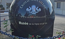 Eine schwarze Deko-Kugel mit weißer Aufschrift weist auf das Weingut Chateau Maucaillou und sein Weinmuseum hin.