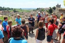 Eine Reisegruppe lauscht in Saint-Emilion den Erklärungen ihrer Reiseleiterin.