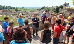 Eine Reisegruppe lauscht in Saint-Emilion den Erklärungen ihrer Reiseleiterin.