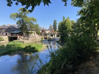 Blick über die Loire zu einer geschichtsträchtigen Gemeinde mit alten Steinhäusern und einer Steinbrücke
