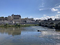 Blick über die Loire zu einer Steinbrücke und einer Gemeinde mit einem prächtigen Schloss