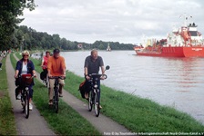 Eine Radlergruppe fährt den Weg entlang den Nord-Ostsee-Kanals