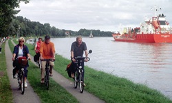 Eine Radlergruppe fährt den Weg entlang den Nord-Ostsee-Kanals