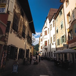 Blick auf die Fußgängerzone mit Café und Tabakladen in der Innenstadt von Bozen