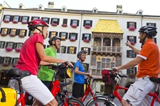 Eine Radfahrergruppe bestaunt das Goldene Dachl in Innsbruck.