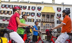 Eine Radfahrergruppe bestaunt das Goldene Dachl in Innsbruck.