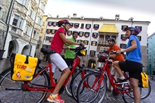 Vier Radfahrer beim Goldenen Dachl in der Innenstadt von Salzburg.