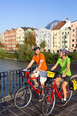 Ein Radlerpärchen auf einer Innbrücke bei Innsbruck.