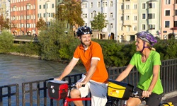 Ein Radlerpärchen auf einer Innbrücke bei Innsbruck.