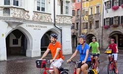 Eine Gruppe von vier Radfahrern in der schmucken Innenstadt von Innsbruck.