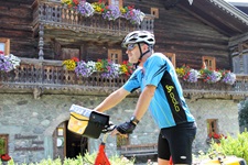 Ein Radler macht vor dem wunderschön mit Blumen geschmückten Klausnerhaus bei Hollersbach im Nationalpark Hohe Tauern Pause.