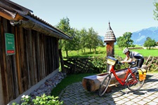 Ein Radfahrer macht an einem Brunnen am Tauernradweg Pause.