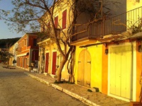 Bunte, von der Sonne angestrahlte Häuser im Zentrum des Ortes Fiskardo auf der Insel Kephalonia.