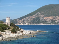 Küste von Kefalonia mit einem Turm der Venezianischen Burg Agios Georgios im Hintergrund